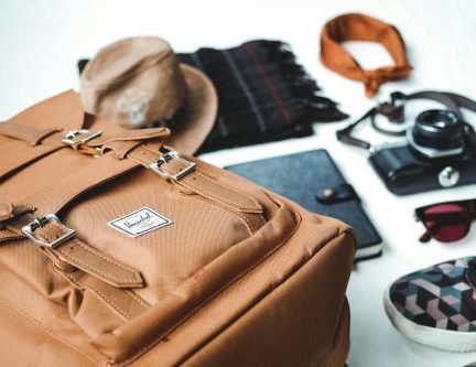 Accessorize - closeup photo of brown leather bag near sunglasses and shoes